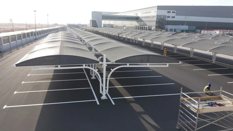 Modern tensile shade canopy over parked vehicles